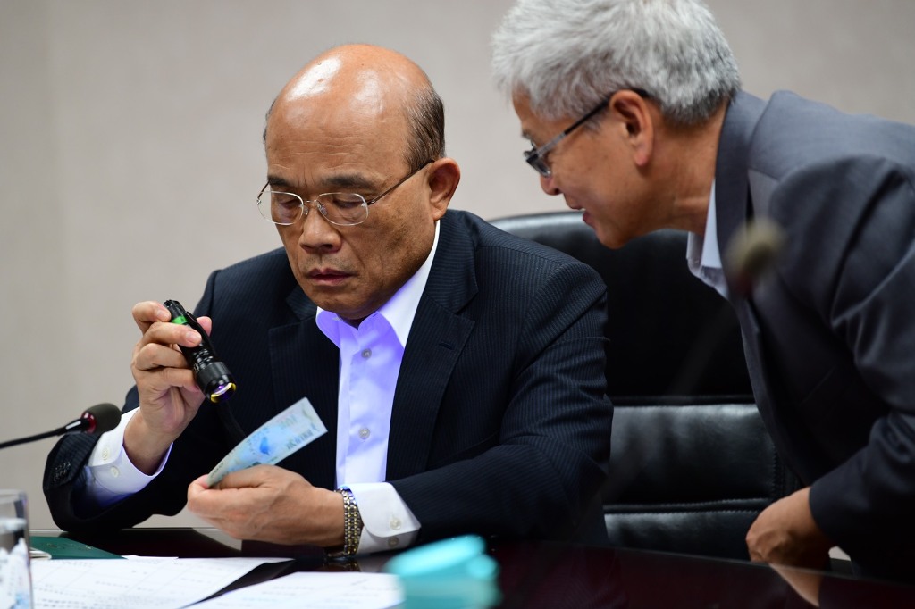 行政院長蘇貞昌透過「看一看」、「摸一摸」、「轉一轉」三原則，了解如何分辨三倍券真偽。 圖：行政院提供