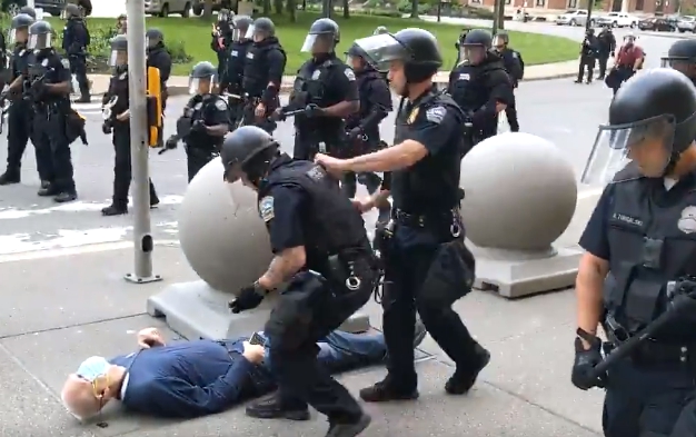 該名男子遭員警推倒後倒地不起，其中一名員警原本要蹲下查看，卻遭身後的同事往前推。 圖：擷取推特@WBFO