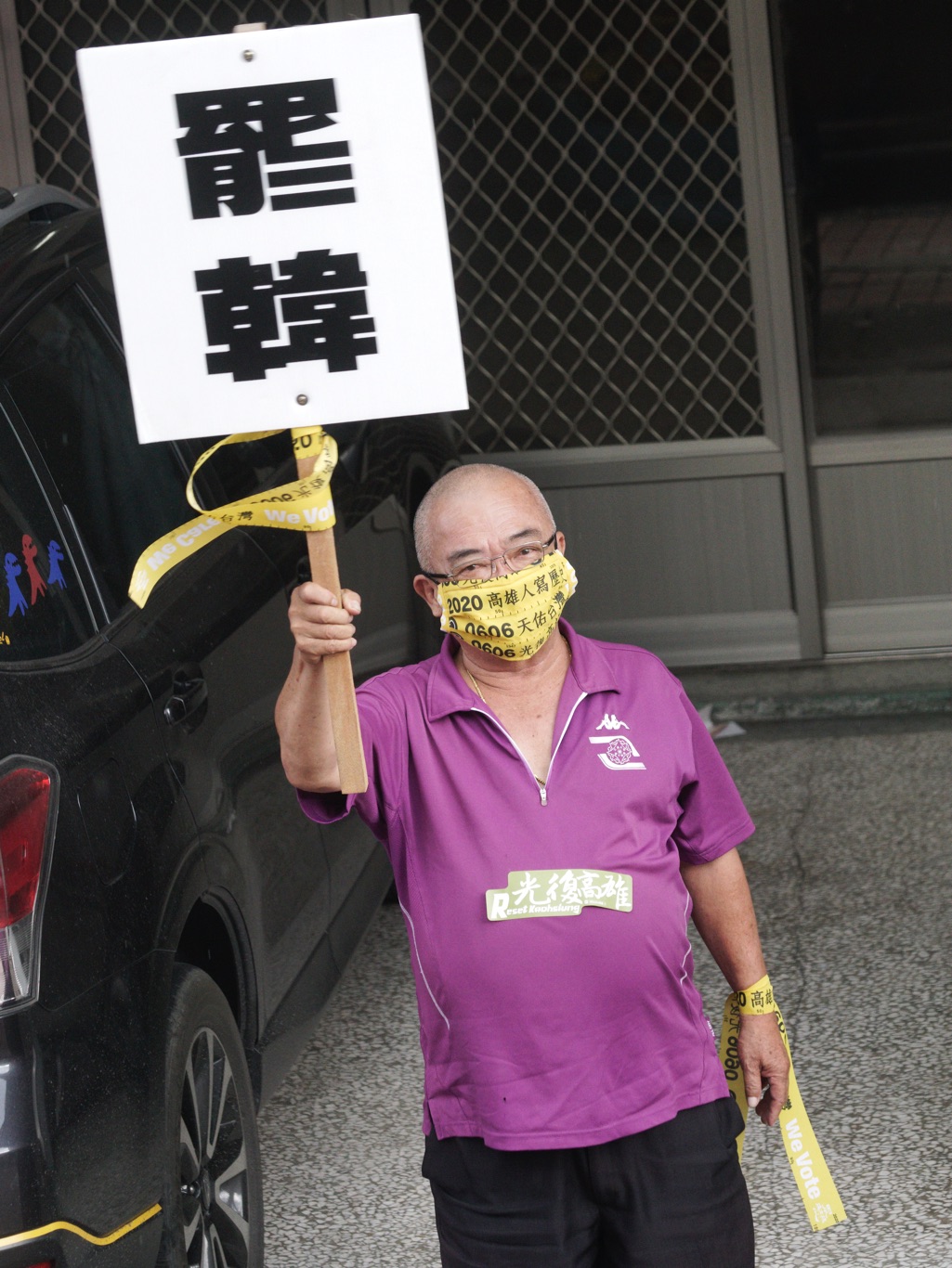 一位市民高舉「罷韓」手舉牌，向罷韓車隊揮手致意。 圖：張良一/攝
