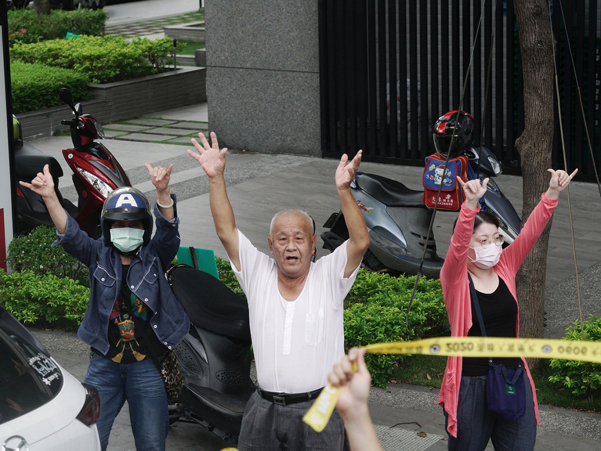 三位市民向罷韓車隊揮手致意。 圖：張良一/攝