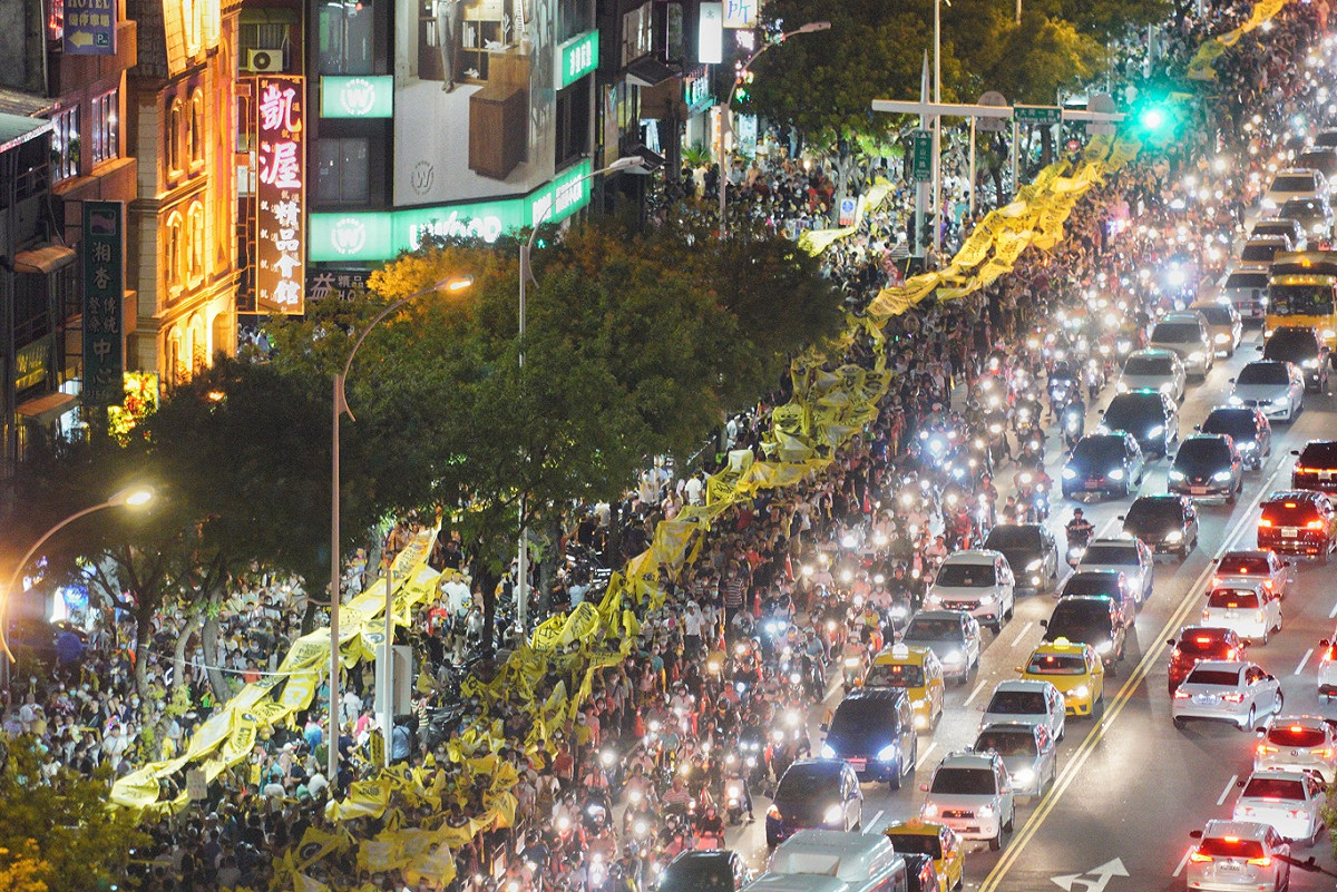 數萬名民眾高舉巨型的民主黃絲帶，參加罷免投票前夕的反恐大遊行，人潮擠爆遊行行經路線，場面相當壯觀。 圖：張良一/攝
