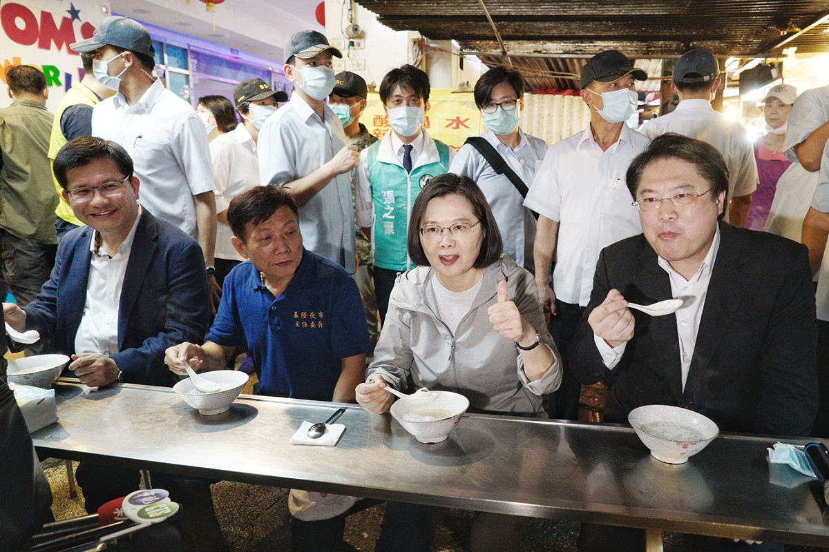 總統蔡英文在內政部長徐國勇、交通部長林佳龍和基隆市長林右昌的陪同下，走訪基隆廟口夜市嚐美食並大力促銷基隆廟口夜市的美食。 圖：張良一/攝