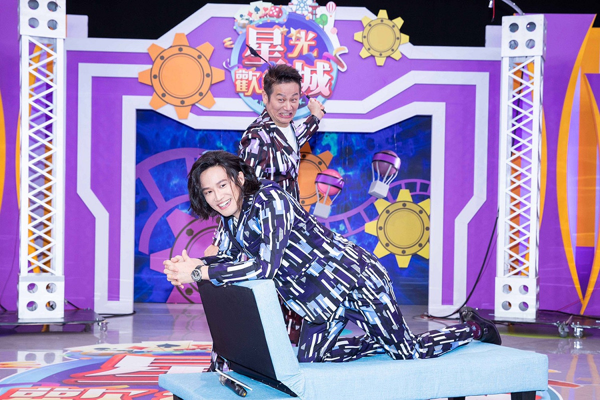 徐新洋(左前)玩撲克牌輸給老爸徐乃麟(右後)，上貴妃椅接受愛的小手打屁股的懲罰。 圖：狼谷育樂台/提供