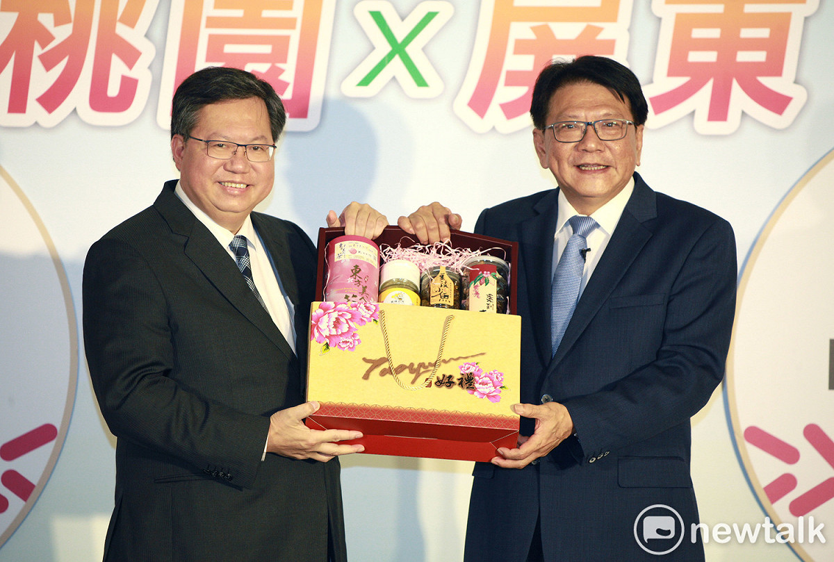 桃園市長鄭文燦（左）贈送桃園市伴手禮給屏東縣長潘孟安（右）。 圖：林昀真／攝