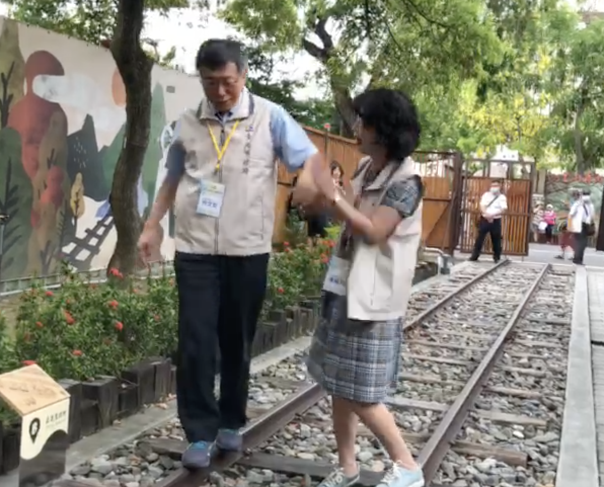 台北市長柯文哲牽妻子陳佩琪手走鐵軌，柯重心不穩多次跌下，讓陳佩琪忍不住伸手打了柯的手。 圖：翻攝影片