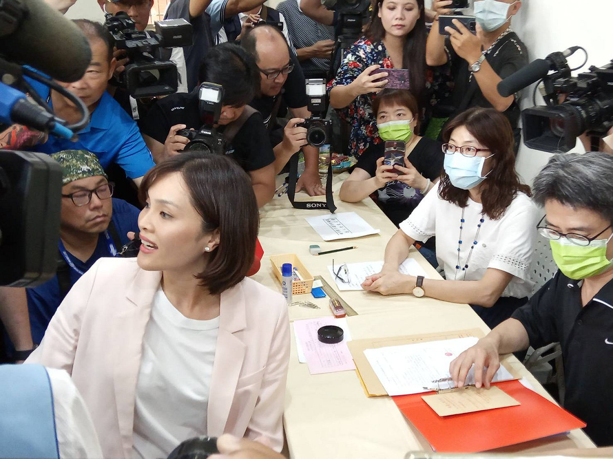 李眉蓁辦理登記時身分證不在身上，轉頭向助理求助。 圖：孫家銘/攝