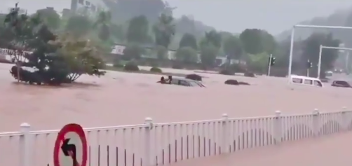 中國湖北宜昌市27日暴雨，網友PO出市區積水嚴重導致車輛被淹情況。 圖：翻攝唐嫣推特