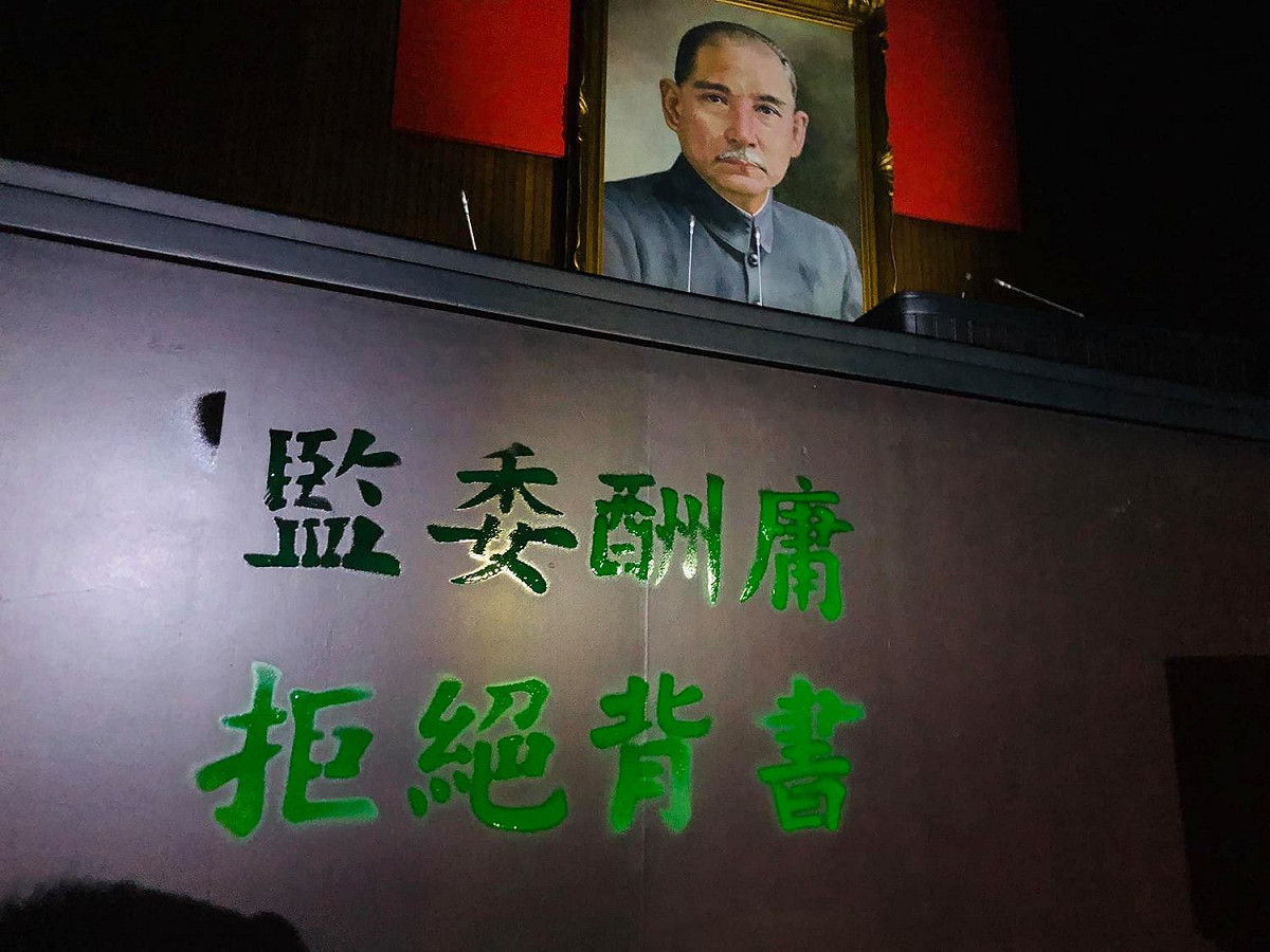 藍委以綠漆在主席台噴下「監委酬庸、拒絕背書」等字。 圖：翻攝自洪孟凱臉書