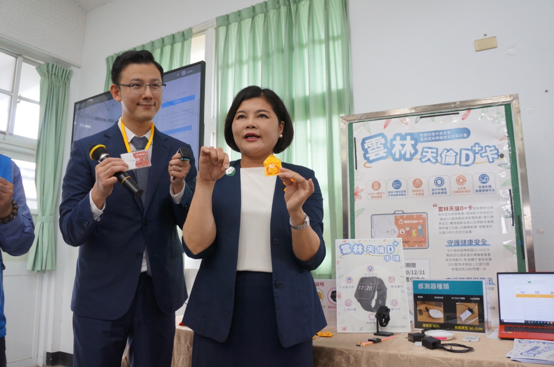 雲林縣長張麗善(右)率智慧時尚股份有限公司總經理張育銓(左)說明「雲林天倫D+卡」具備可12個月持續使用免充電、製成學生證與香火袋方便攜帶與藉由定位技術讓家人以Line獲知使用者位置等優勢 圖／黃耀寬提供