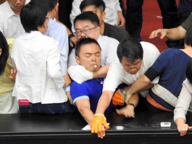 國民黨立委洪孟楷（穿藍衣者）控訴民進黨立委吳秉叡從後方勒脖，形同「殺人」行為，哽咽開記者會。 圖：翻攝自洪孟楷臉書