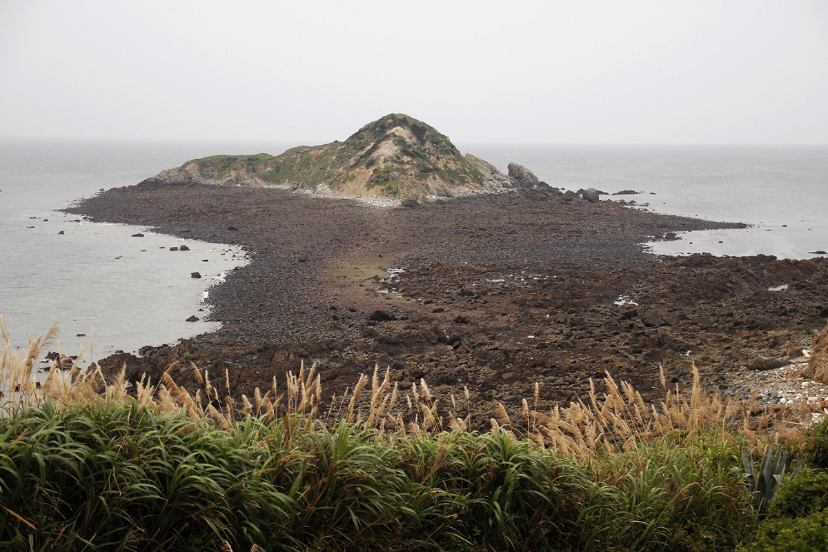 退潮時分，東莒島與犀牛嶼之間的礁石裸露，黃昏時間，常見村民在此撿拾螺貝，讓Jen覺得風景美得像幅畫。 圖：Jen攝影/提供