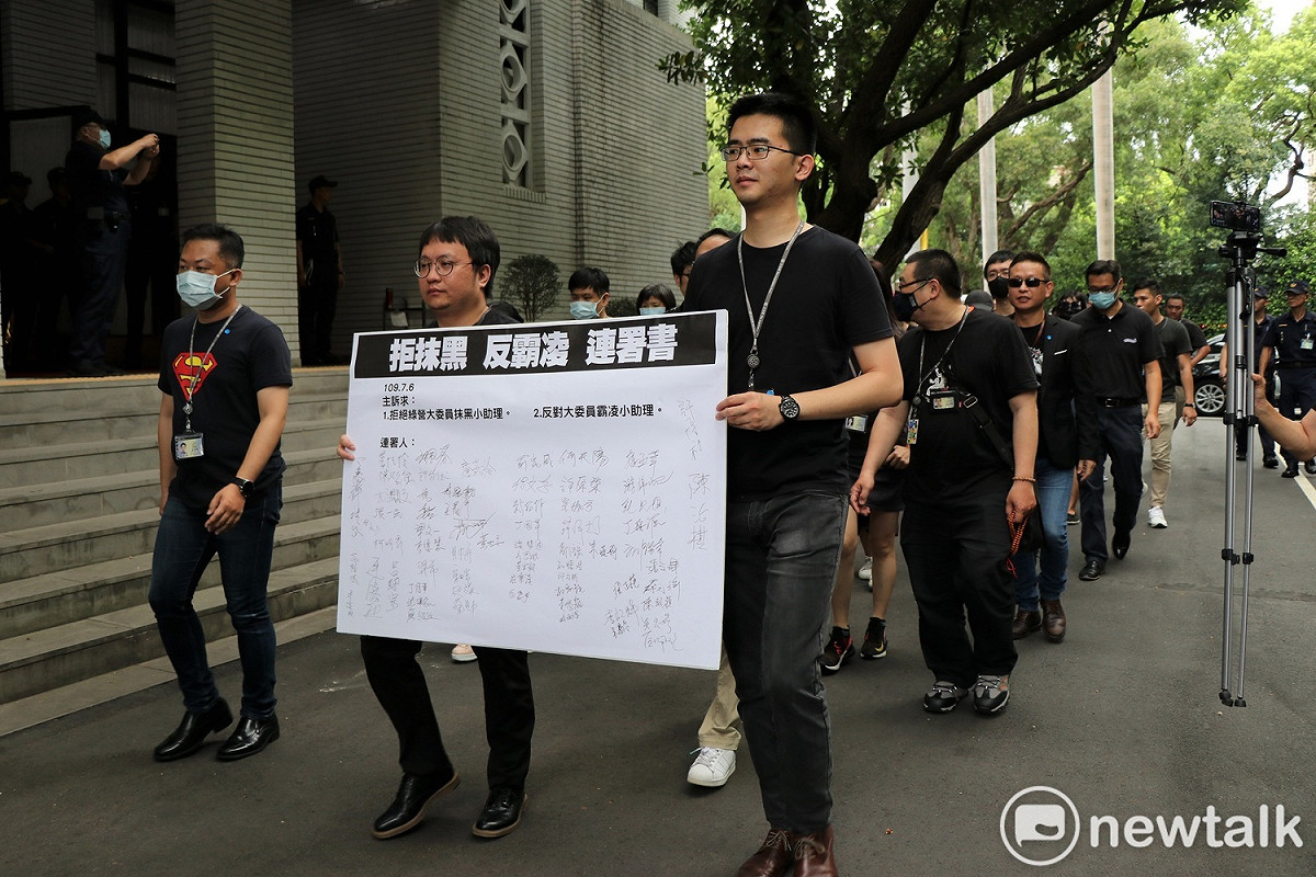 國民黨助理在「拒抹黑、反霸凌」連署書上千名，並繞行議場一圈。 圖：謝孟華/攝