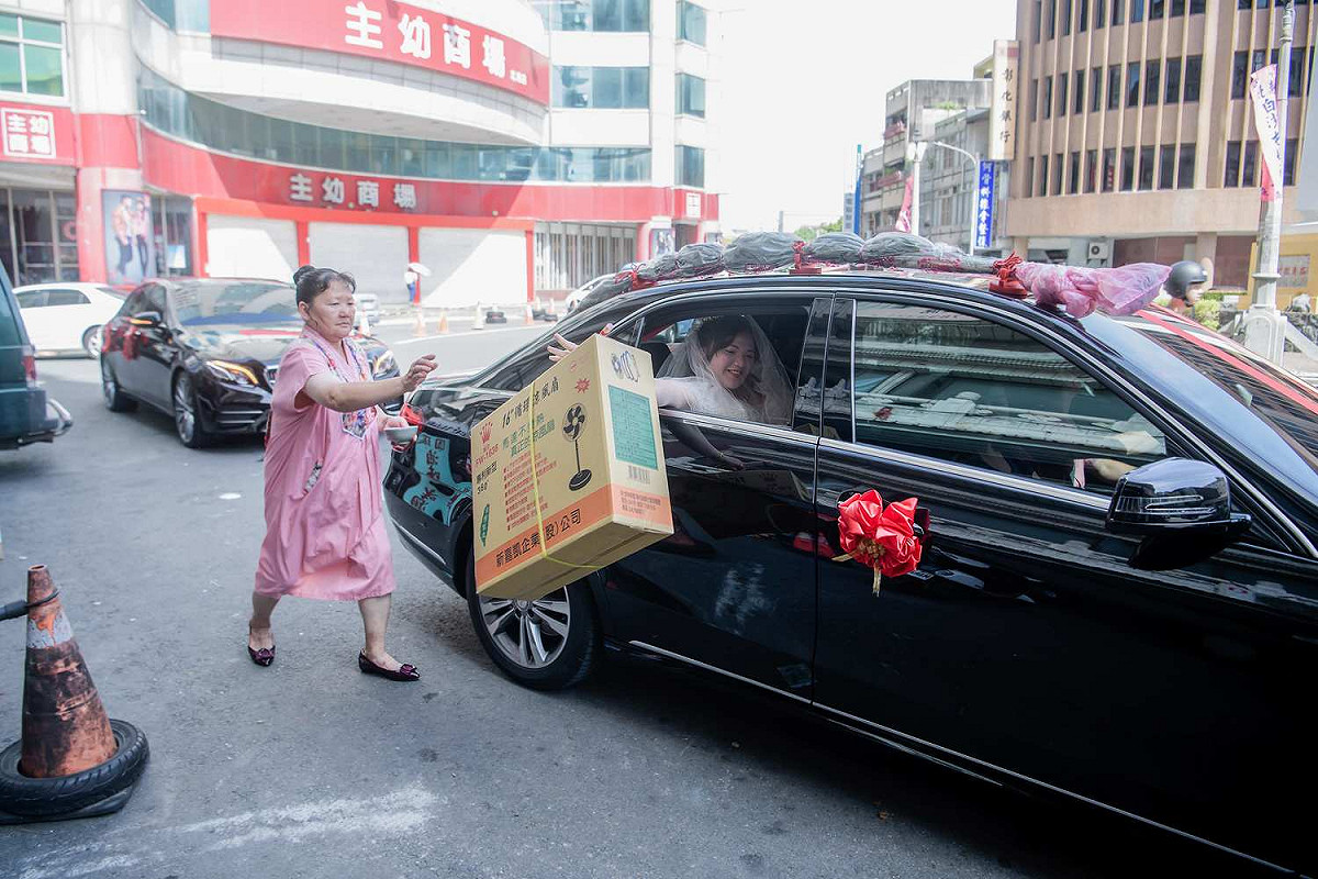新娘吳詩于從禮車上丟下電風扇，頗有創意。 圖：攝影師菜菜大哲/提供