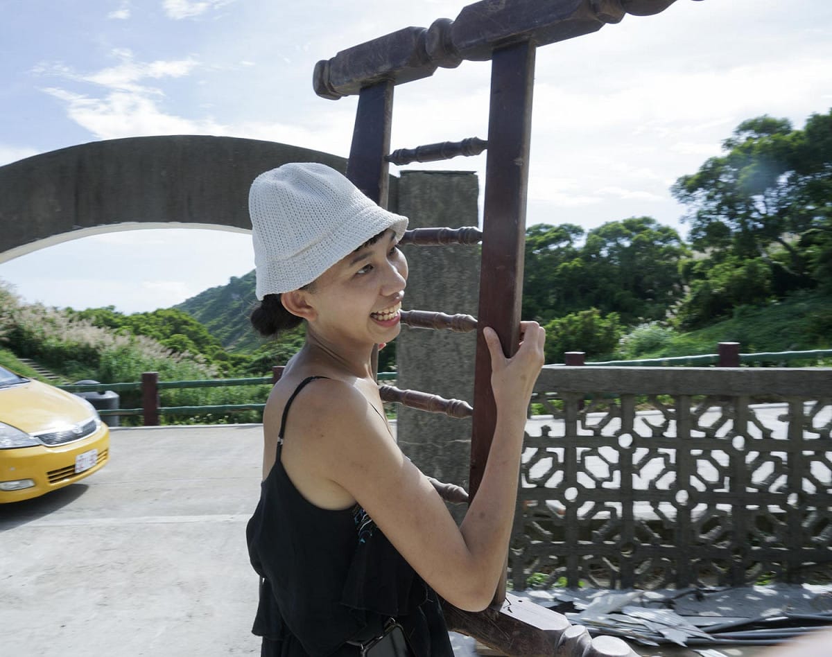 強妮從東莒資源回收場扛回一個廢棄的床架，準備作為重建雞舍時使用。 圖：張良一/攝