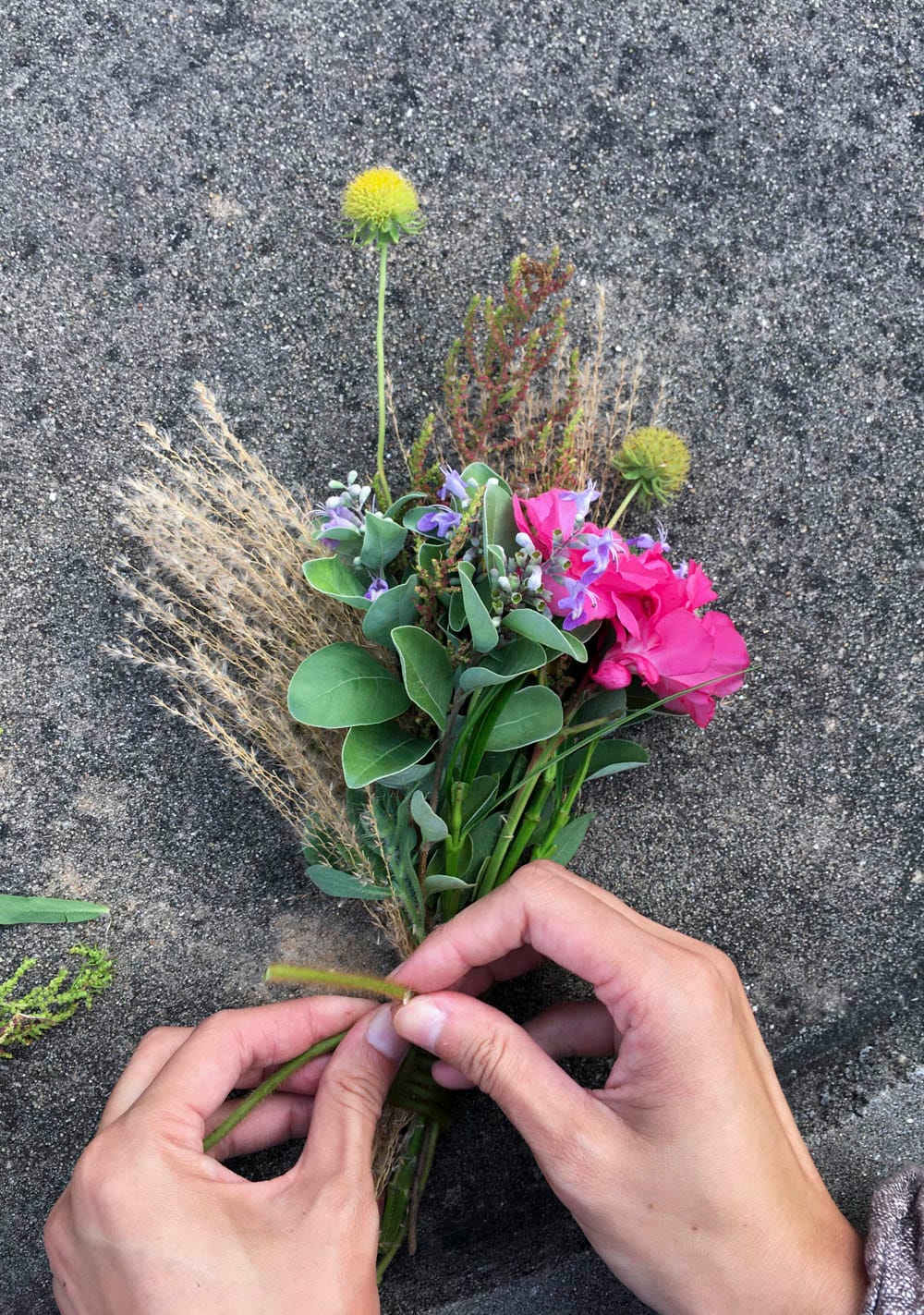 強妮就地取材將野花野草編織成一束捧花，送給東莒國小幼兒園的畢業生林庭妍。強妮喜歡使用自然的植物和大地材料作為創作素材。 圖：張良一/攝