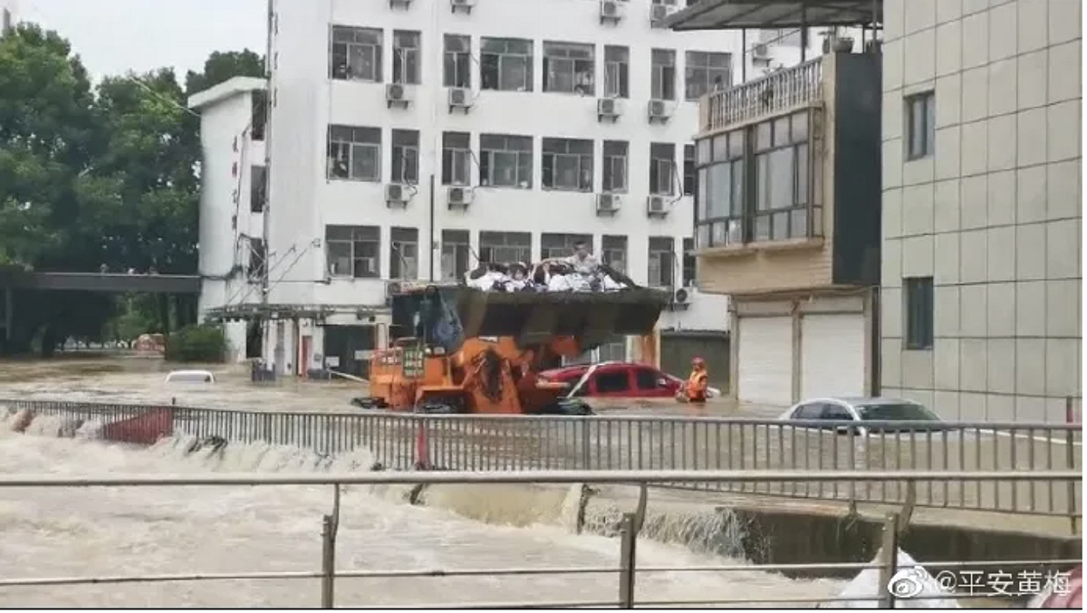 高考生被推土機高舉在上空，度過暴雨造成了洪流，直送考場。