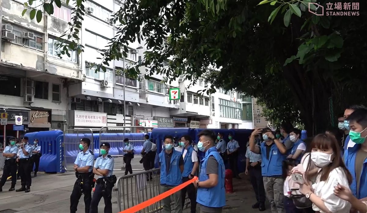 國安署開幕現場被巨架水馬團團圍住，附近街道上也有多名員警戒備。 圖：擷取自立場新聞臉書直播