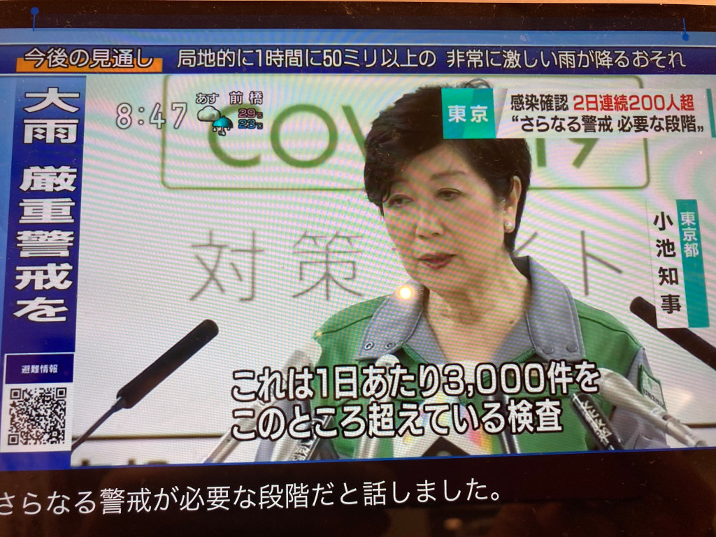 小池每天穿戰鬥服開記者會演出防疫，強調是因為篩檢件數多才會確診多。 圖：攝自NHK