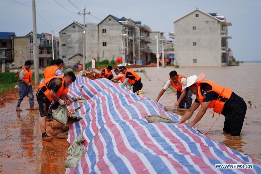 洪災影響區域相當廣，許多民宅因此被淹沒，民眾都不得不動員起來防洪。 圖：翻攝自新華網