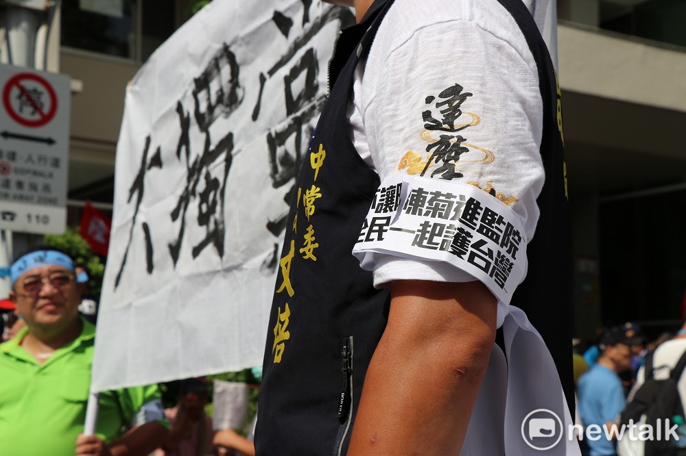 國民黨中常委曾文培戴著「反對陳菊進監察院」的臂章，後方陳抗群眾高舉寫有「一黨獨大」的布條。 圖：謝孟華／攝