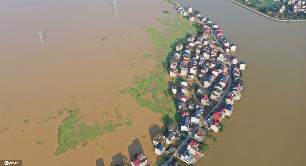 中國境內連日暴雨，造成鄱陽湖周遭住戶房屋淹沒，街道變成河流。 圖 : 翻攝自環球網
