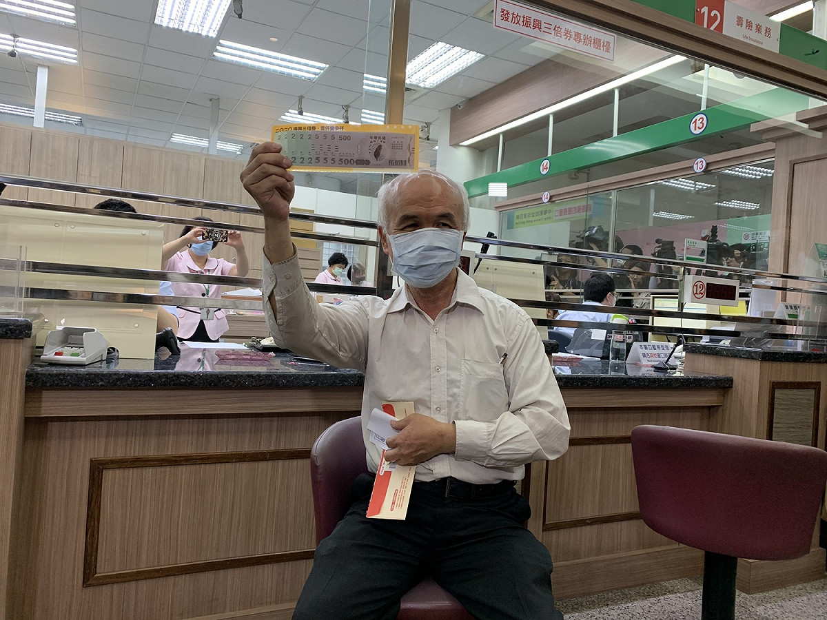 行政院推出的振興三倍券今天正式上路，民眾拿到三倍券露出喜悅的表情。 圖：中華郵政/提供