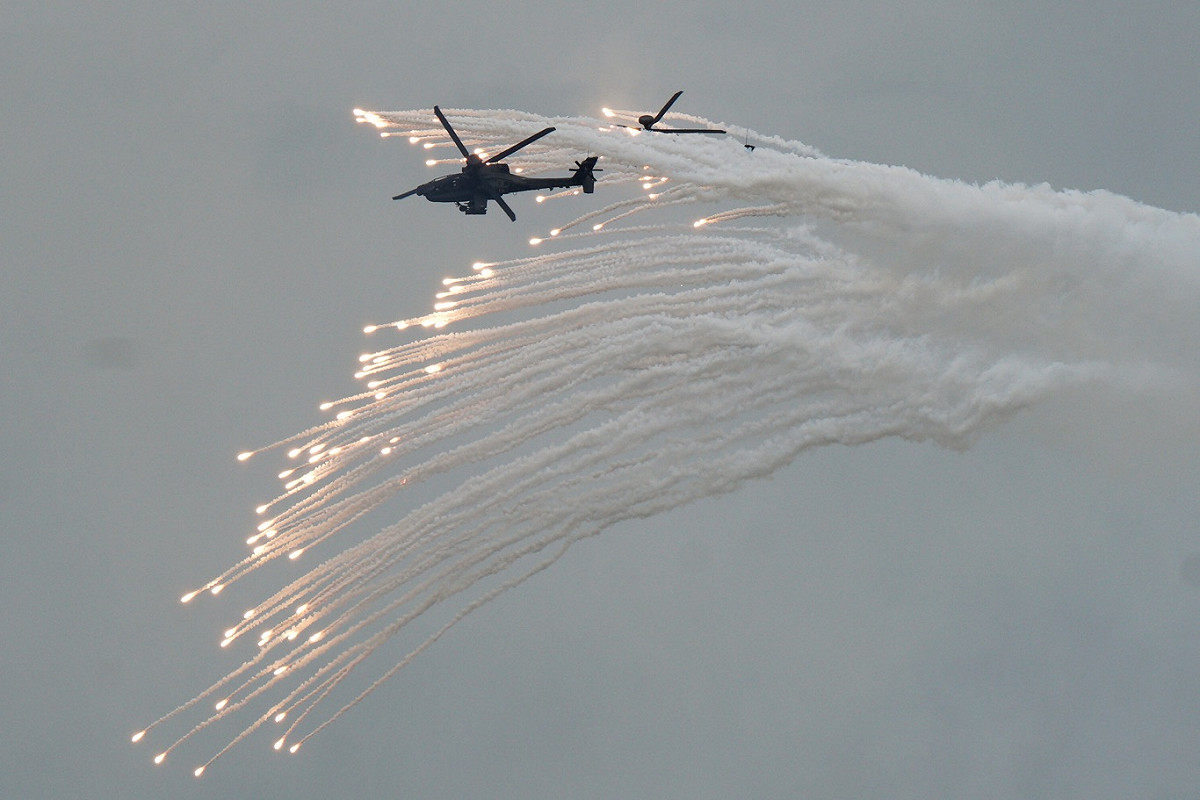 AH-64E阿帕契攻擊直昇機發射地獄火飛彈後，再發射熱焰彈欺敵。 圖：張良一/攝