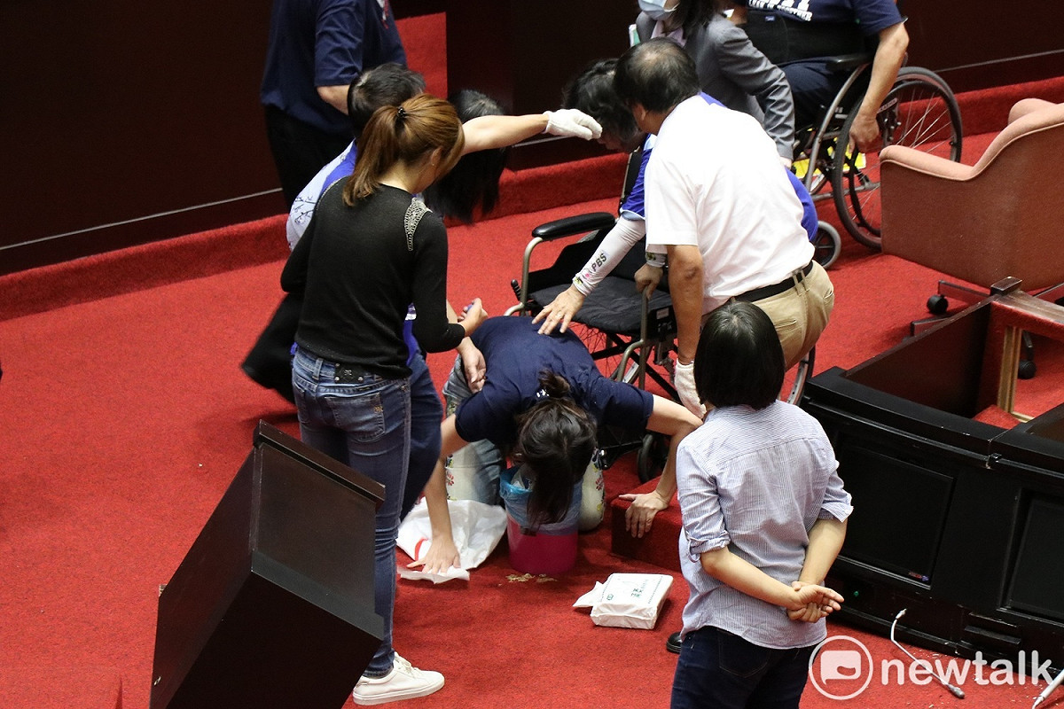 國民黨立委鄭麗文疑似因場面過度壅擠，身體不適而跪在地上嘔吐。 圖：謝孟華/攝