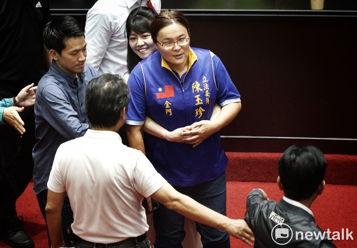 民進黨立委高嘉瑜從後方雙手環抱國民黨立委陳玉珍，勸離她離開投票區。 圖：張良一/攝