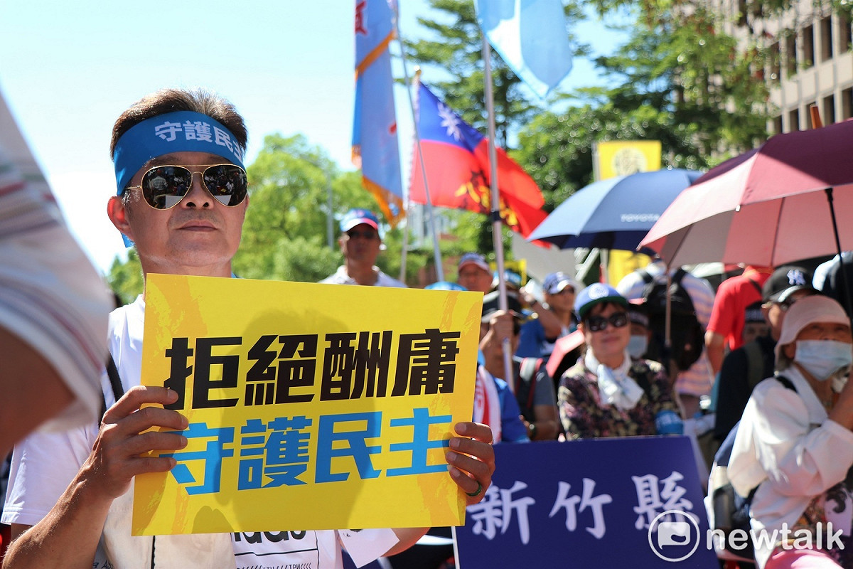 參加抗議的民眾頭綁「守護民主」布條，手持「拒絕酬庸，守護民主」看板，表達對陳菊的不滿。 圖：謝孟華/攝