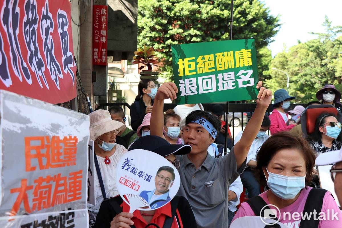 台北韓家軍的帳篷旁，坐滿參加抗議的群眾舉起抗議標語，呼籲民進黨謹慎決策。 圖：謝孟華/攝