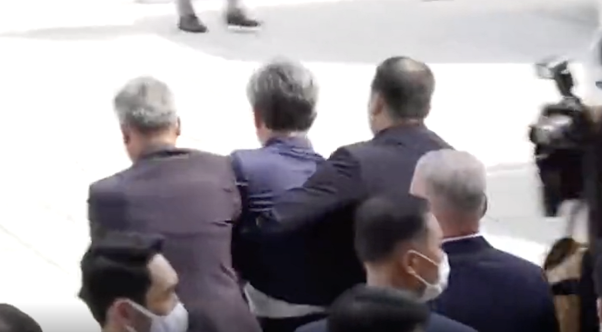 向文在寅丟鞋的抗議者被警方迅速架離現場。 圖：擷取自環球網