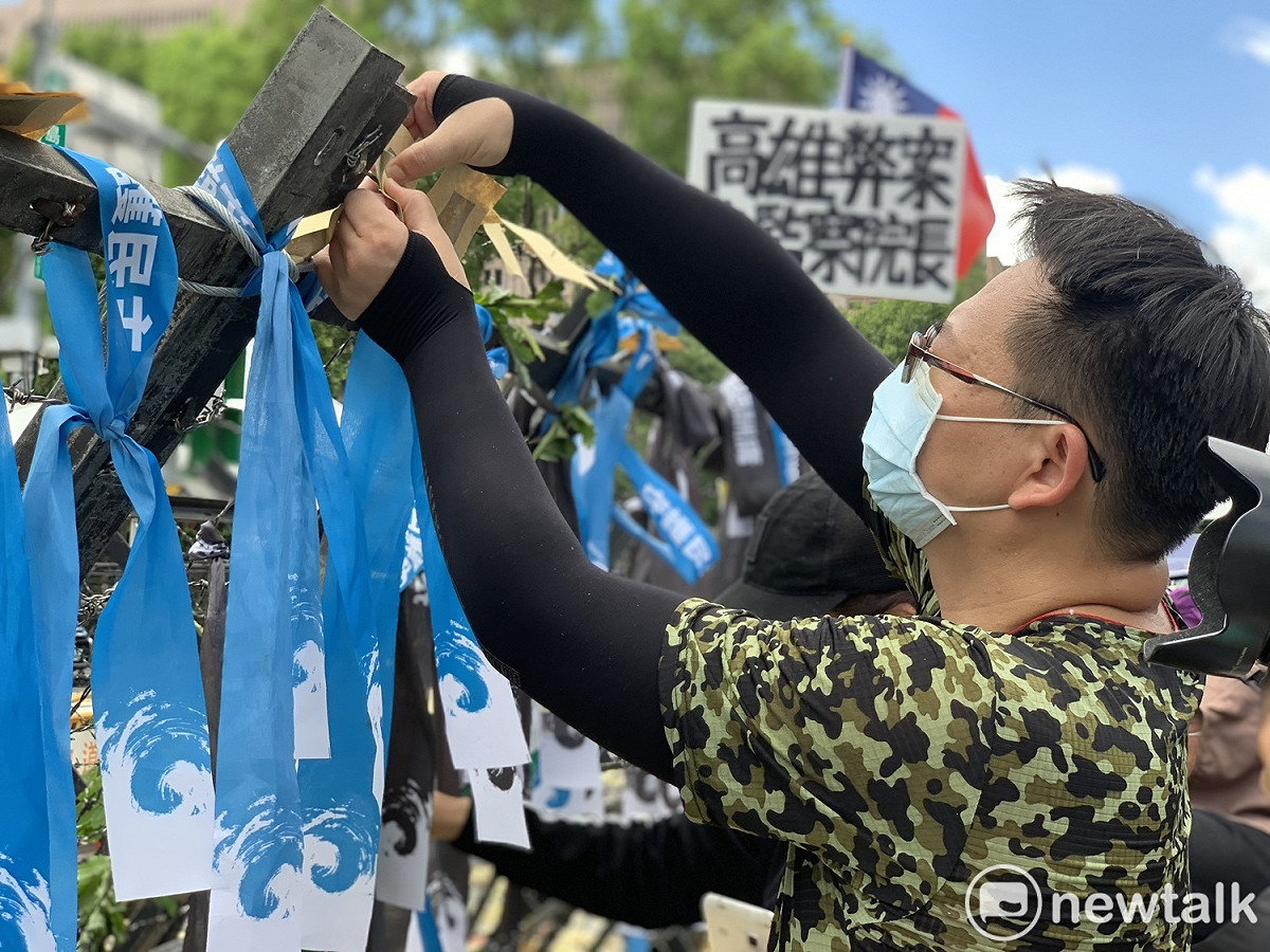 國民黨支持者在拒馬上掛上「拒絕酬庸，守護民主」的紙卡與緞帶。 圖：羅國嘉/攝