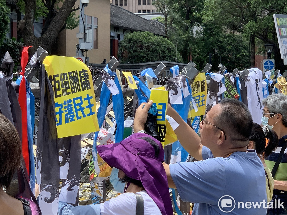 國民黨支持者在拒馬上掛上「拒絕酬庸，守護民主」的紙卡與緞帶。 圖：羅國嘉/攝