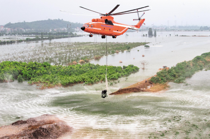 湖北省當局派「Mi-26」直升機向潰口投砂石，欲封堵潰口。 圖：翻攝自湖北日報