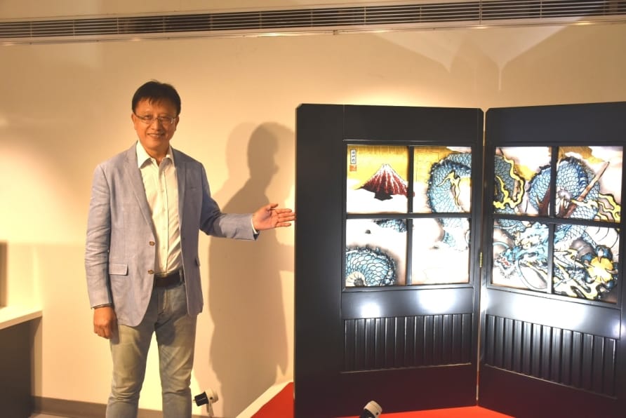 安如公司董事長林華山介紹黒木國昭展覽主軸作品「富山雲龍圖」黃白金彩屏風。 孫家銘／攝