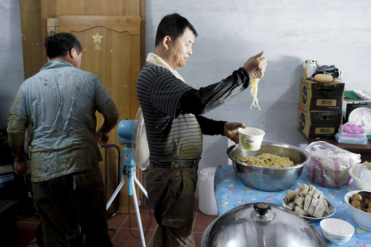 割稻割得滿身大汗，全身濕透的農友們享用田主準備的豐盛點心。 圖：張良一/攝