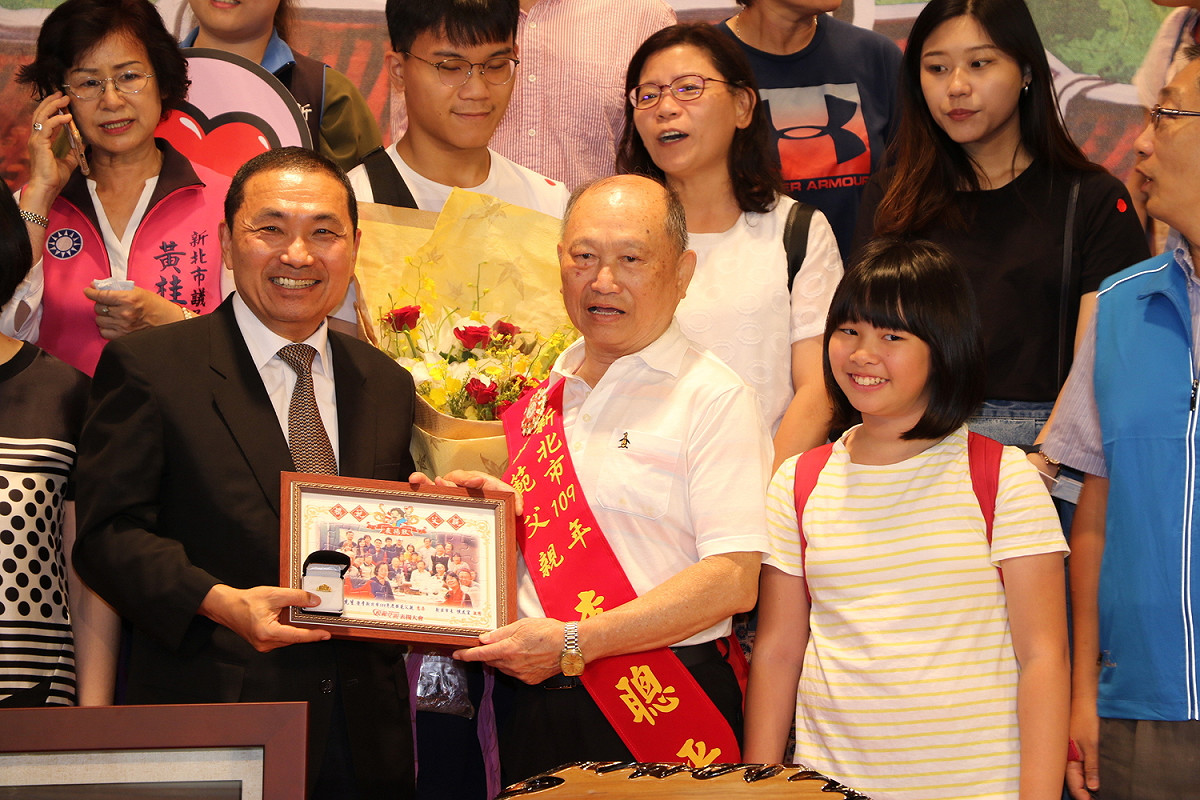 侯友宜向連續當選13屆三重永春里里長李聰平祝賀他榮膺新北市模範父親。 圖：新北市政府提供