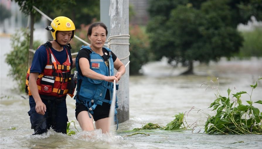 安徽六安市固鎮鎮已經被大水圍困，僅能使用皮艇進入，附近的武警、消防、救援隊均投入救援工作。 圖：翻攝自新華網