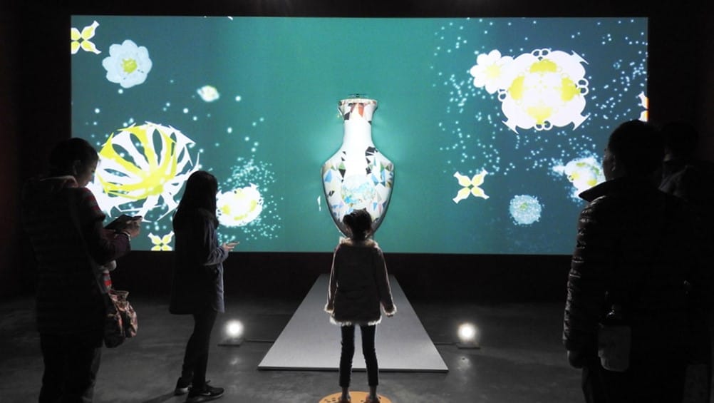 「顏色之樹」，可萃取觀眾身上服裝的色調及花樣，投影到大型陶瓶產生專屬個人的彩繪影像。  圖：鶯歌陶瓷博物館提供