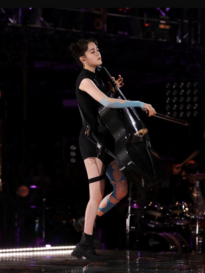 歐陽娜娜頭綁「春麗頭」，右手臂與左腿分別套上藍色絲質的13個破洞褲襪，造型前衛。 圖：翻攝自歐陽娜娜工作室微博
