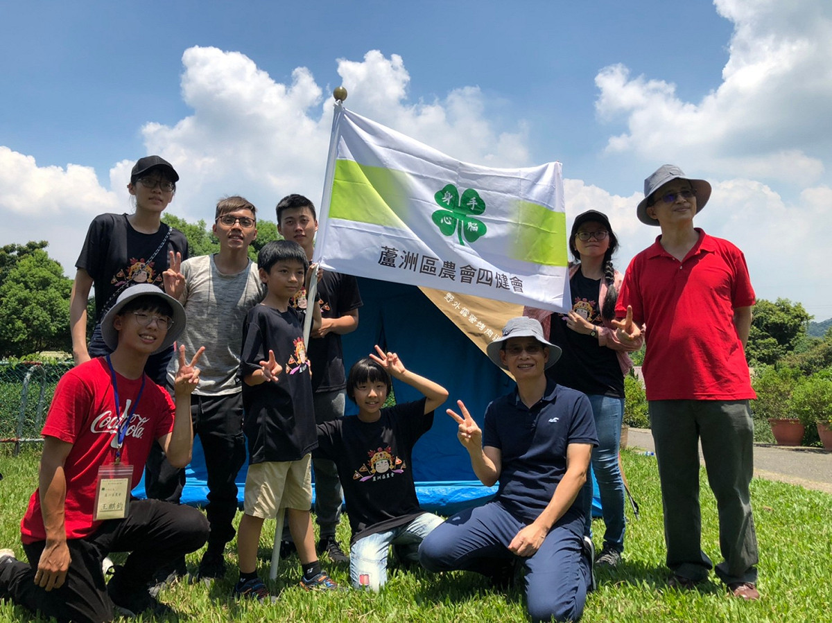 新北市四健會露營活動登場，農業局副局長徐開宇 (前方藍衣灰帽) 與四健會小朋友共同搭營。  圖：新北市農業局提供