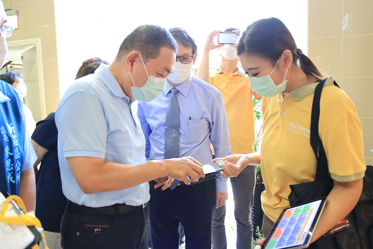 侯友宜試用刷卡、溫度監測上傳雲端，家屬可透過app了解家屬動向集體溫。  圖：新北市衛生局提供