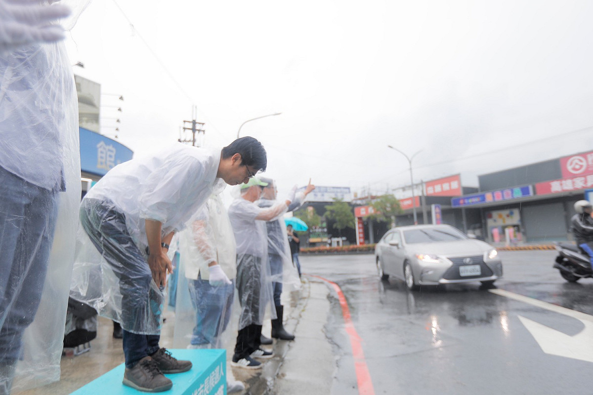 陳其邁(左)持續冒雨在路口向民眾拜票。 圖：陳其邁競辦/競辦