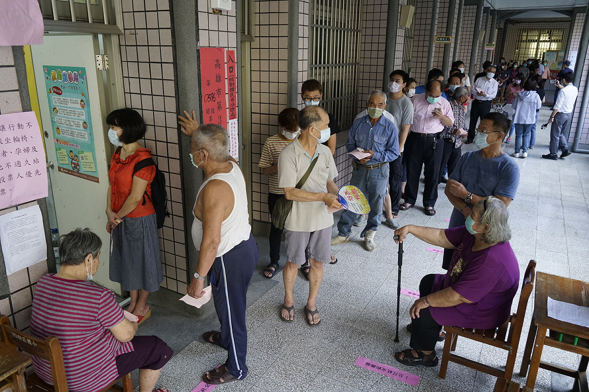 高雄市長補選今登場，民眾戴口罩在外等候投票。 圖：張良一/攝