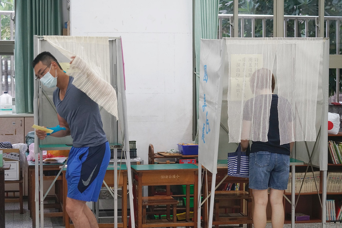 高雄選民一大早就在投票所投票。 圖：張良一/攝