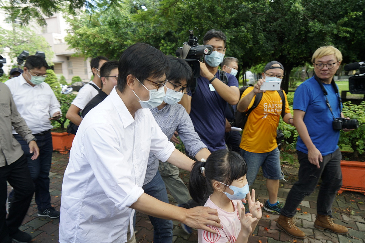 民進黨高雄市長補選候選人陳其邁在新莊國小投票所投完票後，一個小女孩雙手比出象徵勝利的手勢，不過，陳其邁看到有象徵號次的手勢，趕緊跟她說，投票日不要比出有號次的手勢喔。 圖：張良一/攝