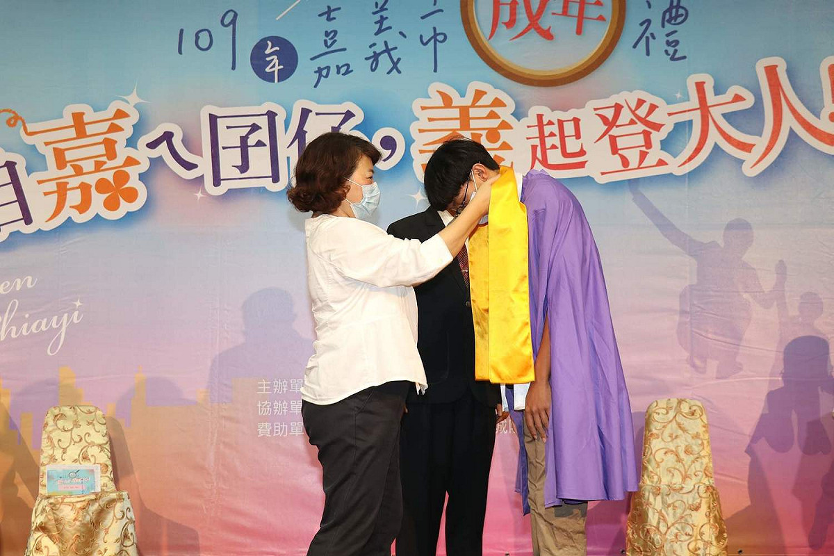 市長黃敏惠為青少年披上黃巾，代表他們即將承擔更大責任。 圖：嘉義市政府/提供