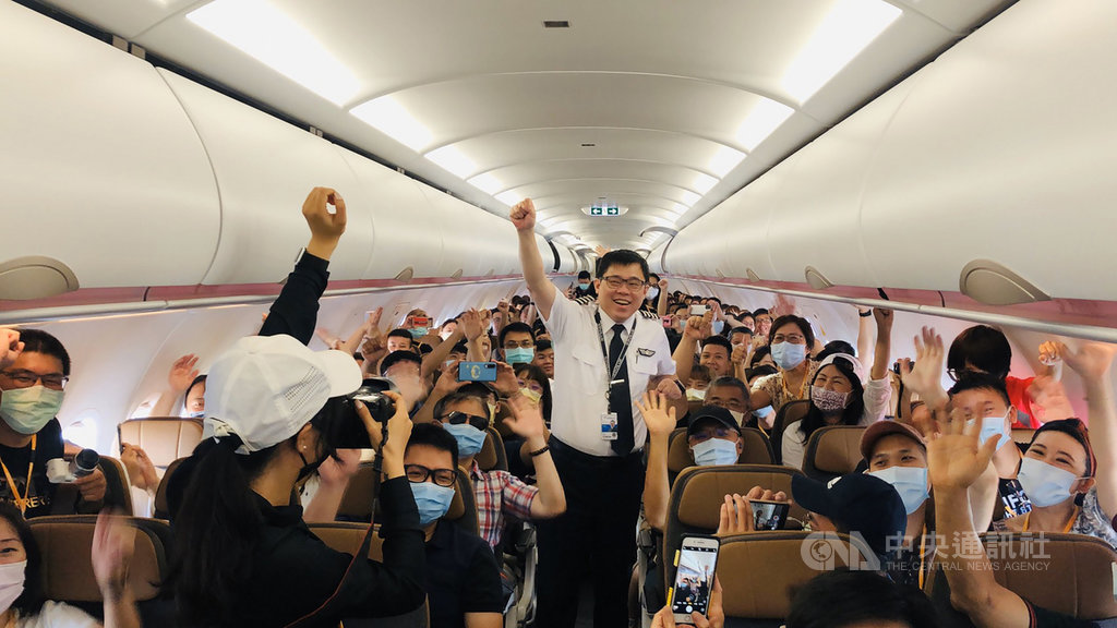 星宇航空董事長張國煒（中）16日開飛機帶員工及粉絲出遊，航程和先前對外銷售的類出國班機差不多，但新增釣魚台上空。張國煒在班機起飛前，現身機艙還與旅客玩大合照。 圖：星宇航空／提供