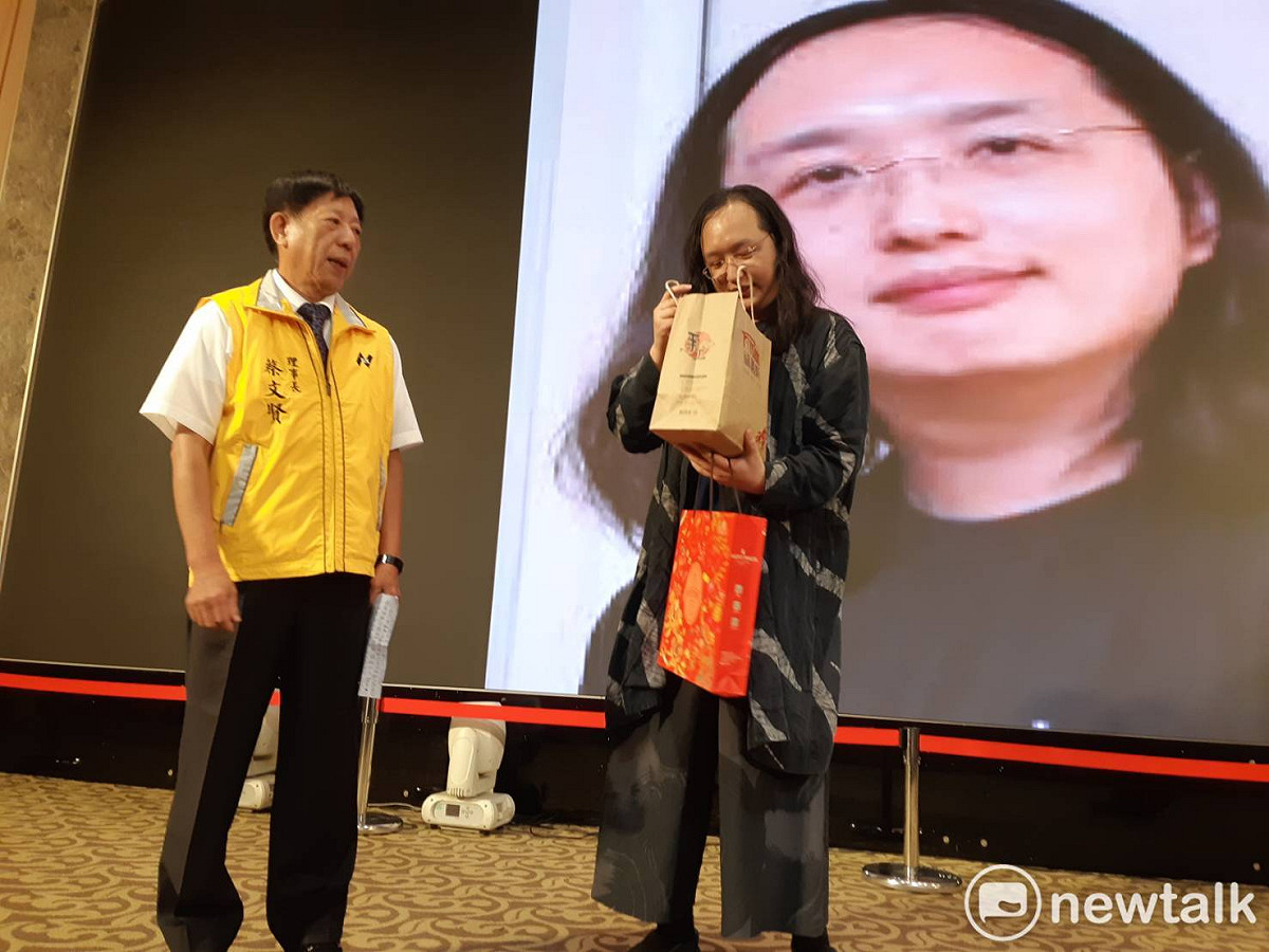 唐鳳今天在嘉義市演講，特別看了一下主辦單位送的嘉義名產蛋捲。 圖：蔡坤龍/攝